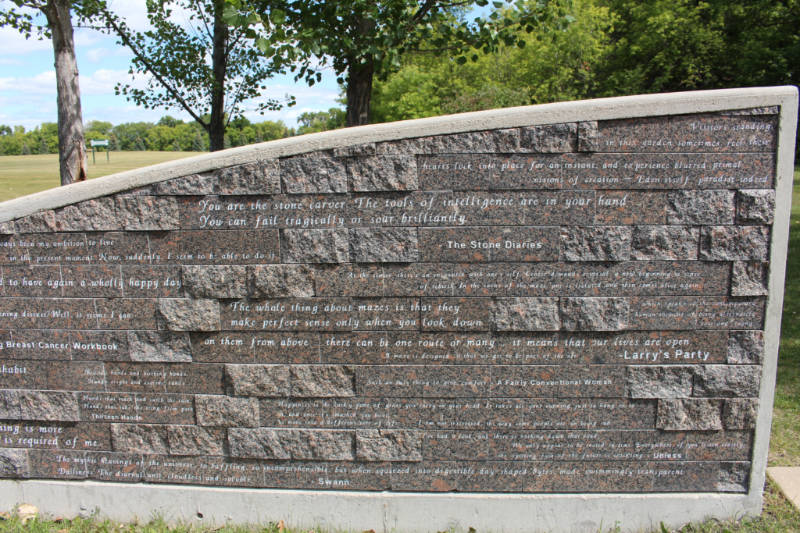 A stone wall with Carol Shields quotes written on it at the Carol Shields Memorial Labyrinth