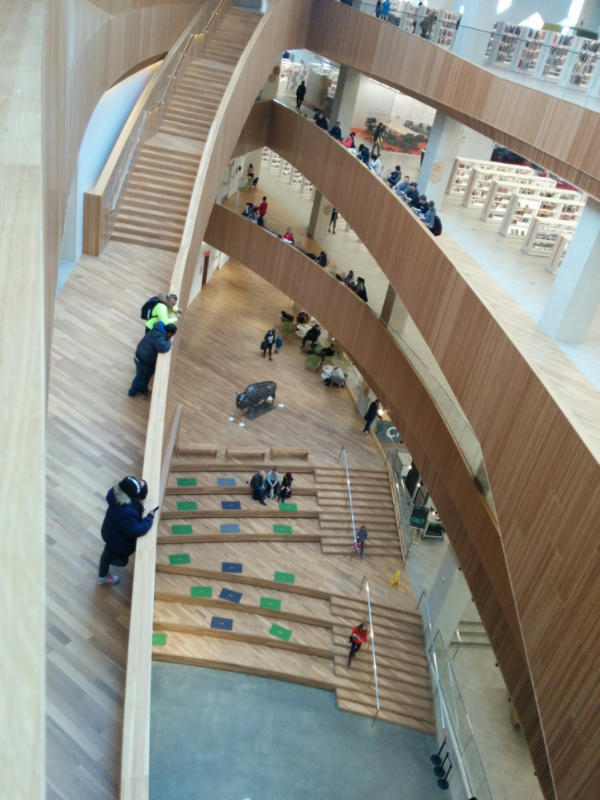 Several stories open to a flowing staircase and the lobby below at the Calgary Central Library 