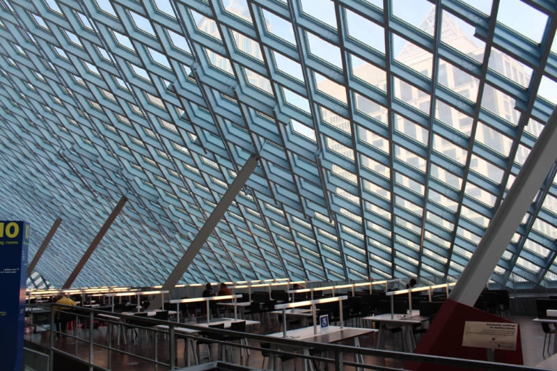 Steel paned window form a wall and a ceiling on one of the interior levels of the Seattle Central Library