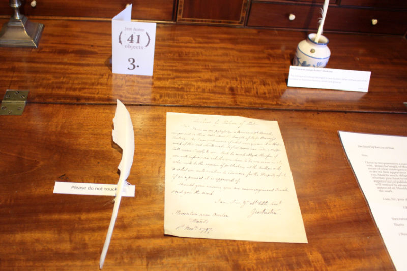 A handwritten letter sitting beside a feather pen on a desk at the Jane Austen House Museum