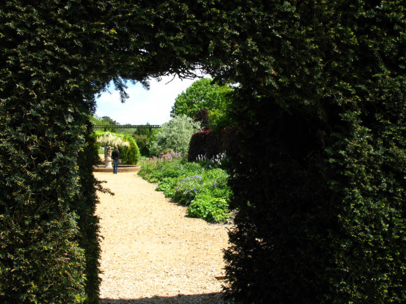 A greenery framed door looking into a garden